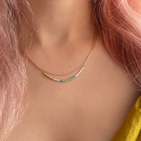 Elvira necklace made of double dainty gold chain decorated with tiny beads in a colorful pattern. Designed by Kurafuchi.