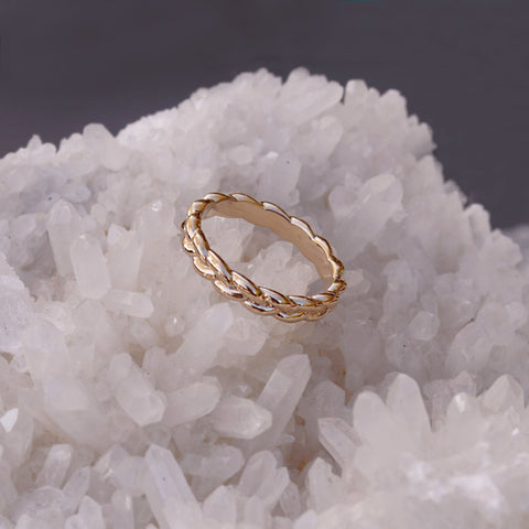 Simple gold band ring in a braided design.