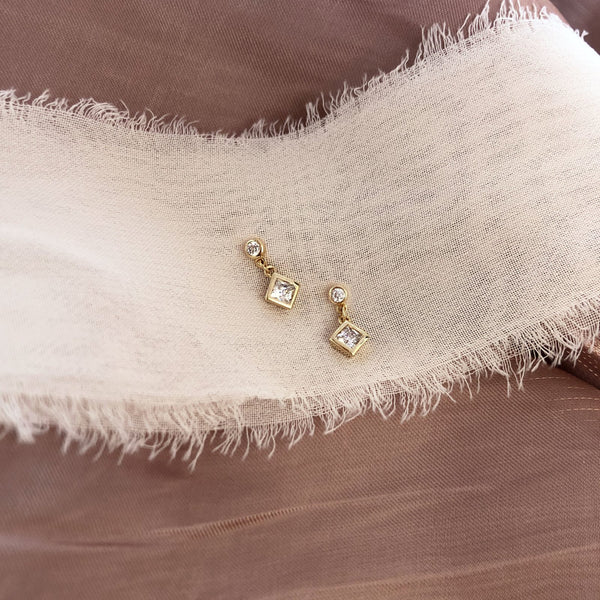 Pretty dangle earrings in a geometric design, with two sparkly zircon crystals. By Kurafuchi.
