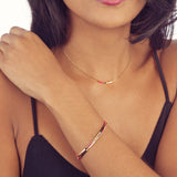 A female model wearing a layered look of minimalist Kurafuchi necklaces.