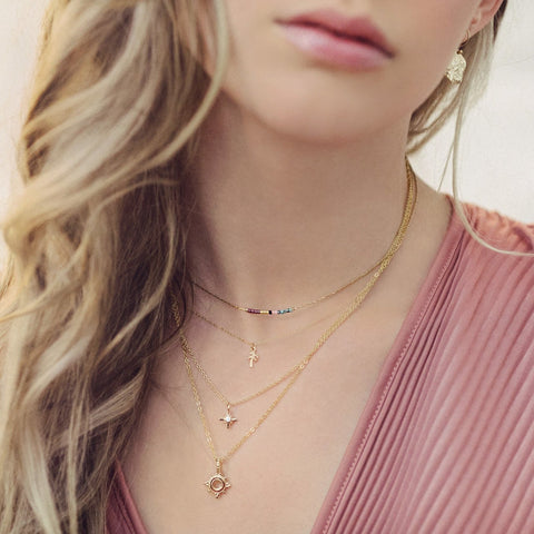 Minimalist necklaces made of a dainty gold chain decorated with tiny beads in a colorful pattern. Designed by Kurafuchi.