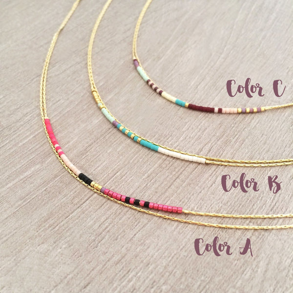 Elvira necklace made of double thin gold chain decorated with small beads in a multicolor pattern. Designed by Kurafuchi.