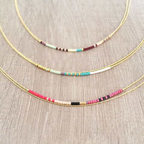 Elvira necklace made of double dainty gold chain decorated with tiny beads in a colorful pattern. Designed by Kurafuchi.