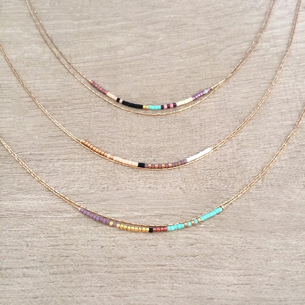 Elvira necklace made of double thin rose gold chain decorated with tiny beads in a multicolor pattern. Designed by Kurafuchi.