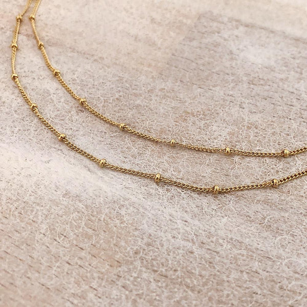 Double-strand necklace made with a delicate gold beaded chain. Designed by Kurafuchi.