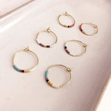 Dainty wire hoops decorated with little beads in multicolor patterns. The hoop diameter is 20mm. By Kurafuchi.