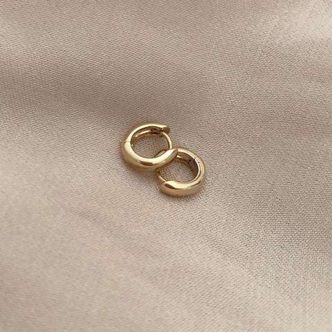 Simple thick gold hoops with a smooth finish.