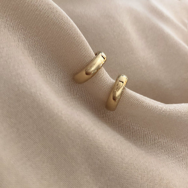 Simple thick gold hoops with a smooth finish.