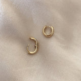 Simple thick gold hoops with a smooth finish.