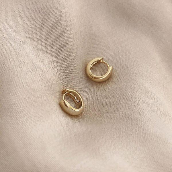 Simple thick gold hoops with a smooth finish.