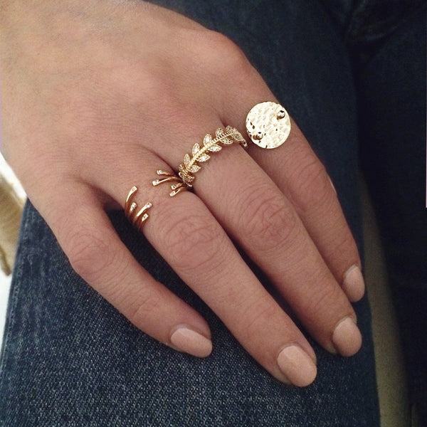A female model’s hand featuring a combined look of multiple Kurafuchi gold rings over several fingers.