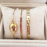 A photo of three Kurafuchi gold bracelets.