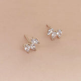 Sparkly gold stud earrings made of three teardrop-shaped zircon crystals.