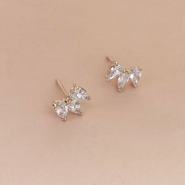 Sparkly gold stud earrings made of three teardrop-shaped zircon crystals.
