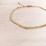 Ankle bracelet made of a flat curb chain with a mirror finish.
