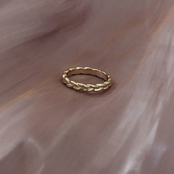 Simple gold band ring in a braided design.