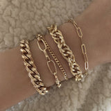 A female model’s wrist showcasing a layered look of Kurafuchi gold bracelets in various designs and thicknesses.