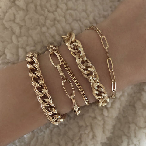 Chunky gold bracelet made of a thick chain of textured links interlaced. By Kurafuchi.