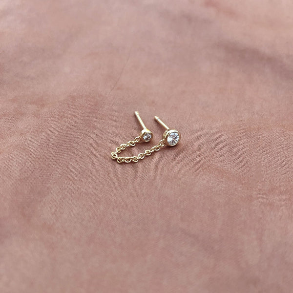 Double stud earrings made of a dainty gold chain finished by a zircon crystal on each end. By Kurafuchi.