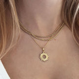 A female model wearing a combination of gold pendant necklaces.