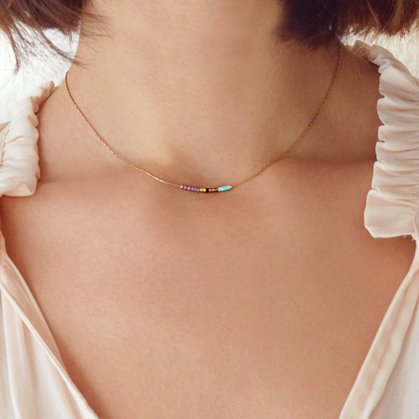 A female model wearing a minimalist rose gold dainty necklace by Kurafuchi Jewelry.