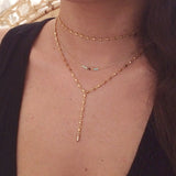 A female model wearing a layered look of gold Kurafuchi necklaces.