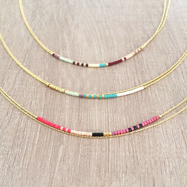 Elvira necklace made of double dainty gold chain decorated with tiny beads in a colorful pattern. Designed by Kurafuchi.