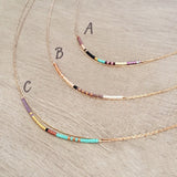 Elvira necklace made of double thin rose gold chain decorated with tiny beads in a multicolor pattern. Designed by Kurafuchi.