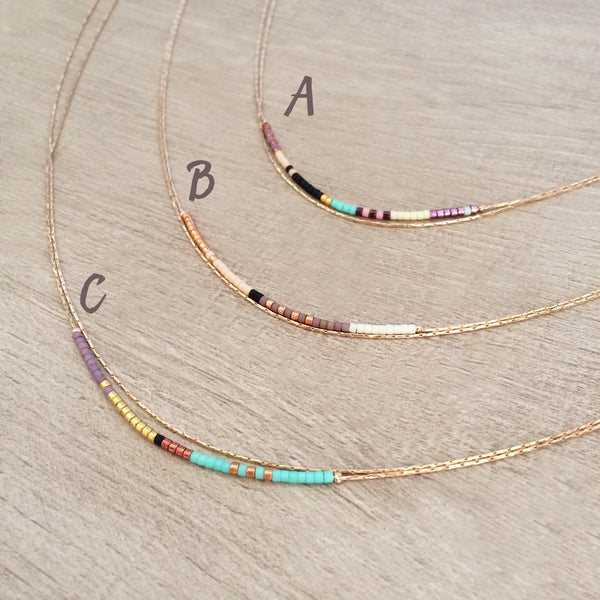 Elvira necklace made of double thin rose gold chain decorated with tiny beads in a multicolor pattern. Designed by Kurafuchi.