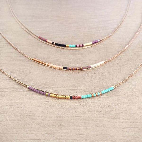 Elvira necklace made of double dainty rose gold chain decorated with tiny beads in a colorful pattern. Designed by Kurafuchi.