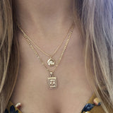 A female model wearing a layered look of gold pendant necklaces by Kurafuchi Jewelry.