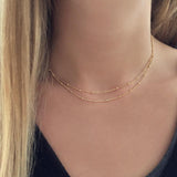 A female model wearing a gold double-strand chain necklace by Kurafuchi Jewelry.