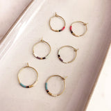 Dainty wire hoops decorated with little beads in multicolor patterns. The hoop diameter is 20mm. By Kurafuchi.
